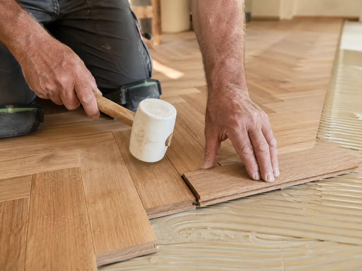 Oak herringbone blocks being laid by hand