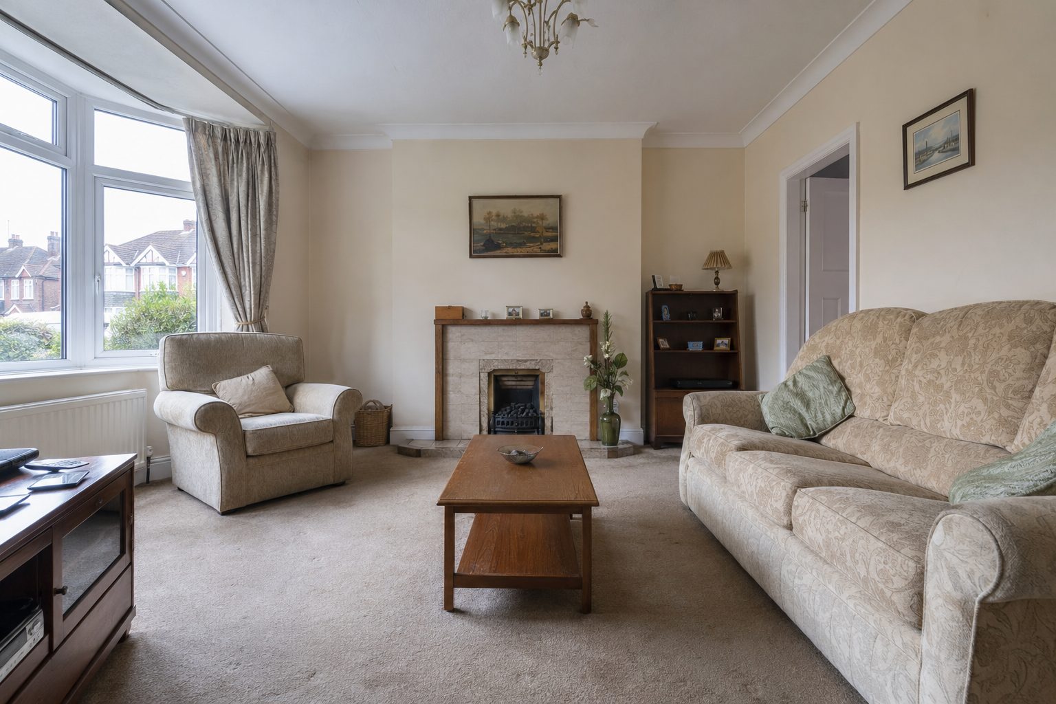 Before: Traditional living room with patterned suite and beige carpet